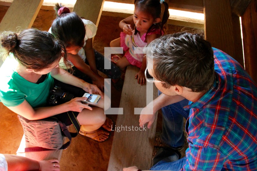 missionaries showing children their cellphones 