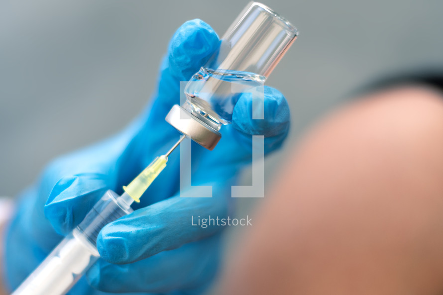 Scientist holding a syringe and vaccine vial. Global alert. Vaccination. Covid-19. Coronavirus. Research.