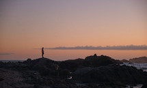 man standing on a rocky shore 