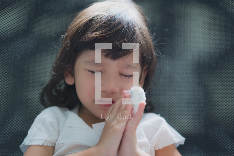 child with a hurt hand praying 