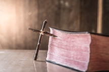 cross made of sticks next to a Bible 