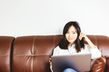 woman sitting on a couch working from home 