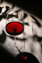 Wine glass on table with shadows