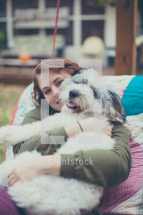 a woman snuggling with a dog 