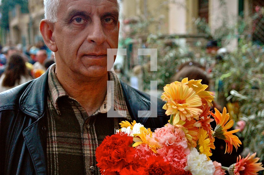 a man carrying a bouquet of flowers 
