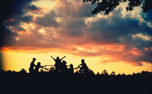 silhouettes of children playing on a playground at sunset 