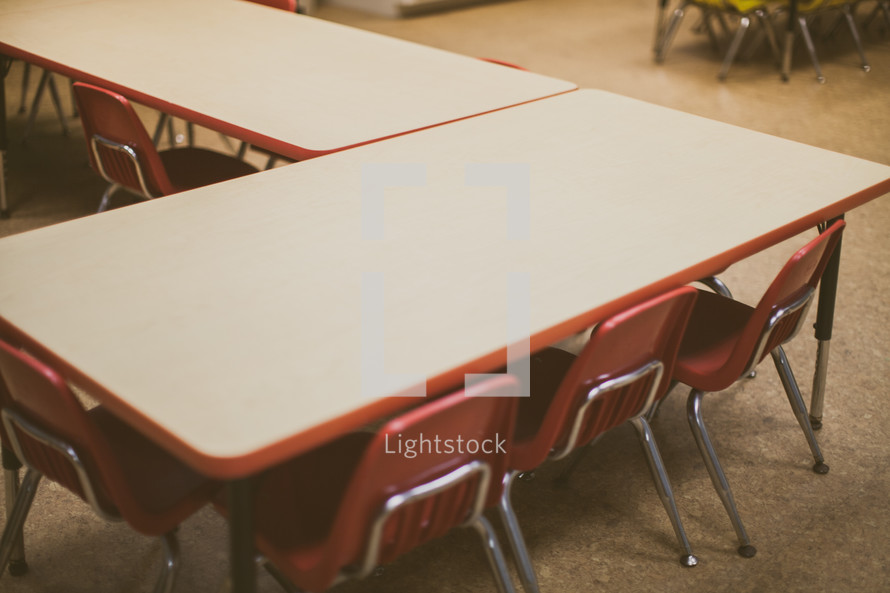 chairs under a table in a classroom 