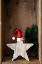 Christmas star with a santa hat in a wooden crate 