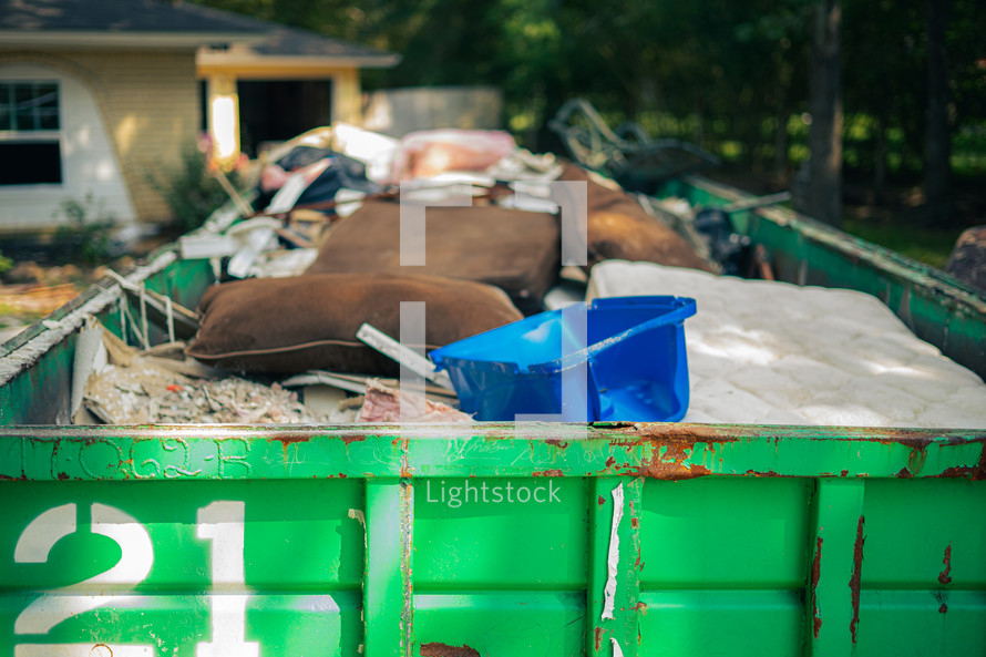dumpster in front of a house - cleaning up after flood damage 