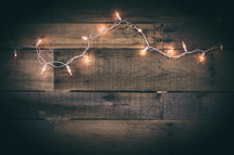 String of White Lights on Aged Wood Background