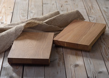 Two empty chopping boards for dishes on wooden background