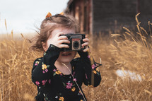 a child taking a picture with an old camera 