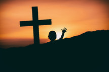 a girl standing near a cross