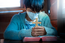 person wearing a face mask with praying hands 