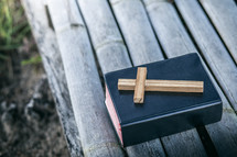 a wooden cross on a Bible outdoors 