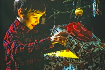 Eight year old boy opening Christmas present