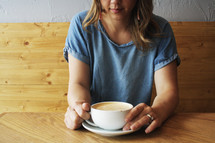 woman sitting in a booth with coffee 