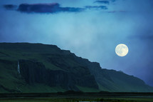 full moon over green cliffs 