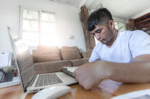 Man praying with computer laptop, Online church in home, Home church during quarantine coronavirus Covid-19, Religion