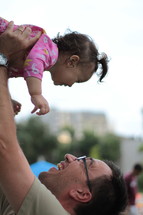 Father lifting his child in the air.