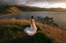 bride standing by a lake 