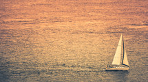 sailboat in the ocean at sunset 