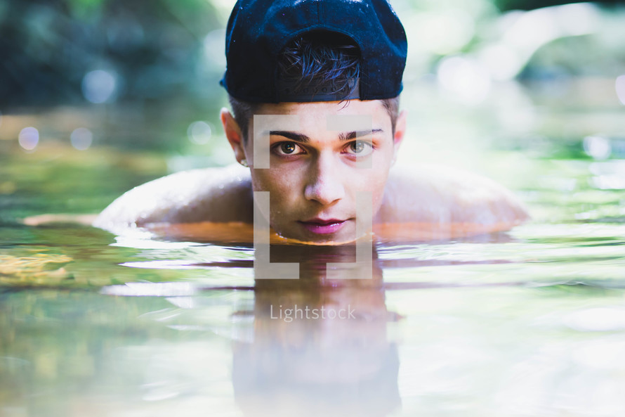 teen boy standing in deep water 