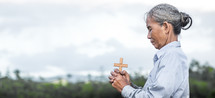 a woman holding a cross praying 