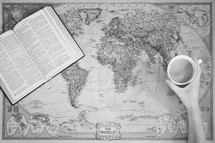 Bible and mug on a world map 