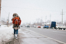 woman walking down a street on a sidewalk 