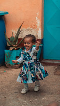 Portrait of a happy little girl dancing and smiling.