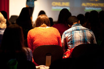 Couple in audience during a bible study presentation.