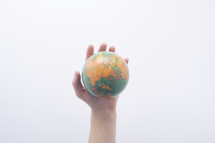 hand holding up a globe 