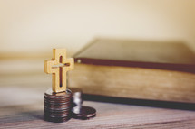 Bible, stack of coins, and cross