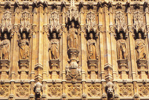 saints and royalty carved into stone on a building 