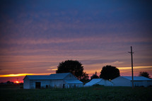 white barns at sunset 