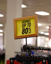 A sign on a clothing rack in a store for an discount sale. Use it for a Black Friday or after Christmas concept.