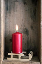 red candle in a wood crate 