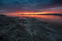 rocky shore at sunset with red sky 