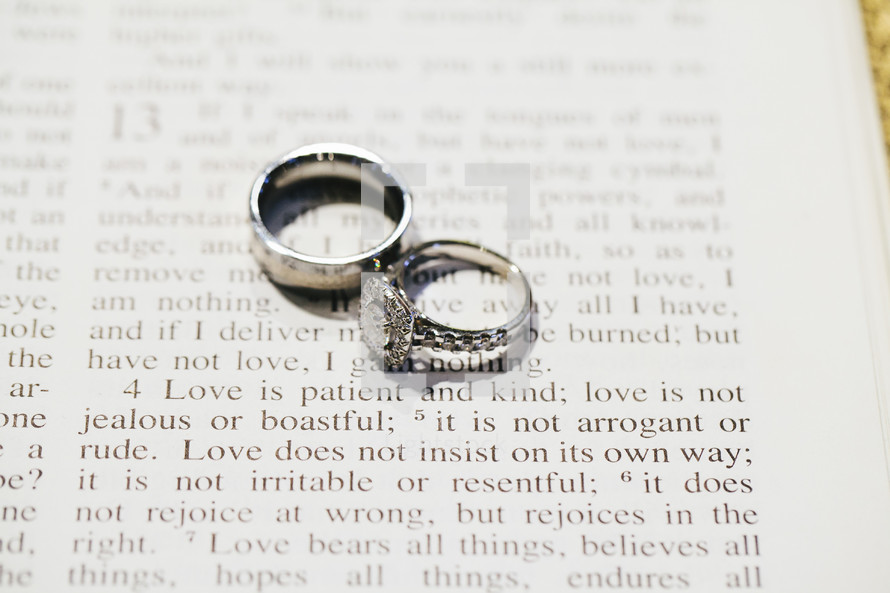 wedding band and engagement ring on the pages of a Bible