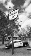 old Sinclair gas station sign and vintage car 