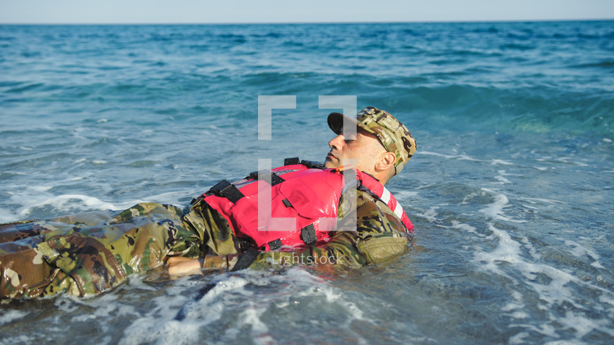 Military man with camouflage and life jacket as safety concept