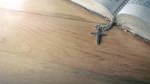 cross necklace on the pages of a Bible 