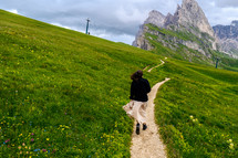 a woman walking on a path on a mountainside 