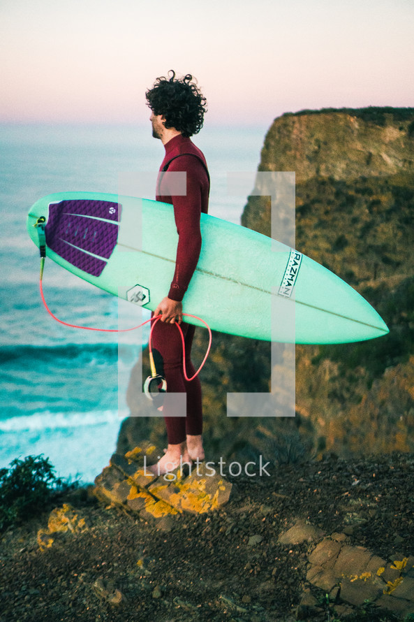 surfer standing on a shore 