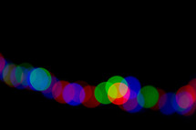 colorful bokeh Christmas lights against a black background 