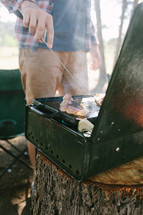 a man cooking breakfast at a camp site