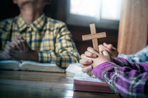 Children group Bible study praying holding a cross