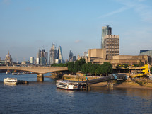 LONDON, UK - CIRCA JUNE 2018: Waterloo bridge, the National Theatre and river Thames view at sunset, with the city skyscrapers in the background