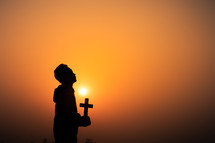 Christian holding the Cross with light sunset background, Christians should worship and thank God, Christian silhouette